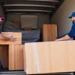 Movers Calgary expertly packing the truck with furniture, showcasing teamwork in a vibrant urban setting.